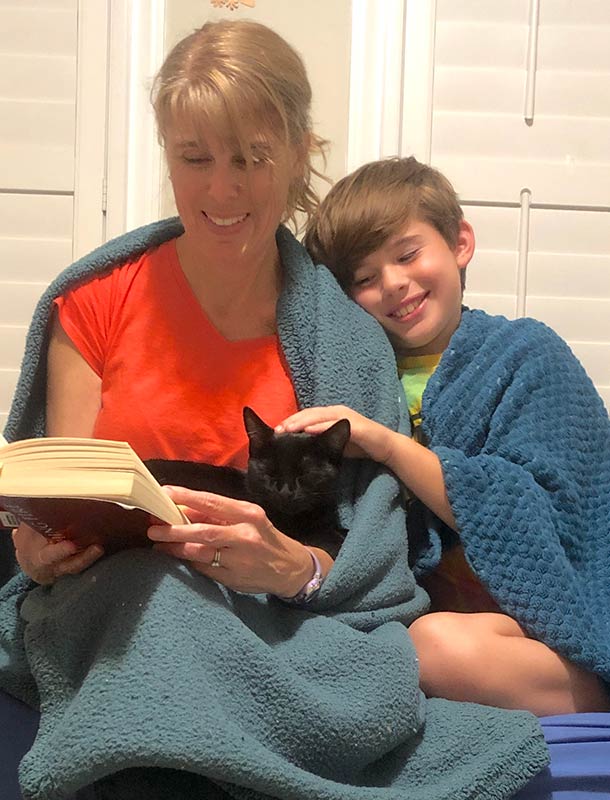 Photo of Kristi J. Smith reading a book with her son